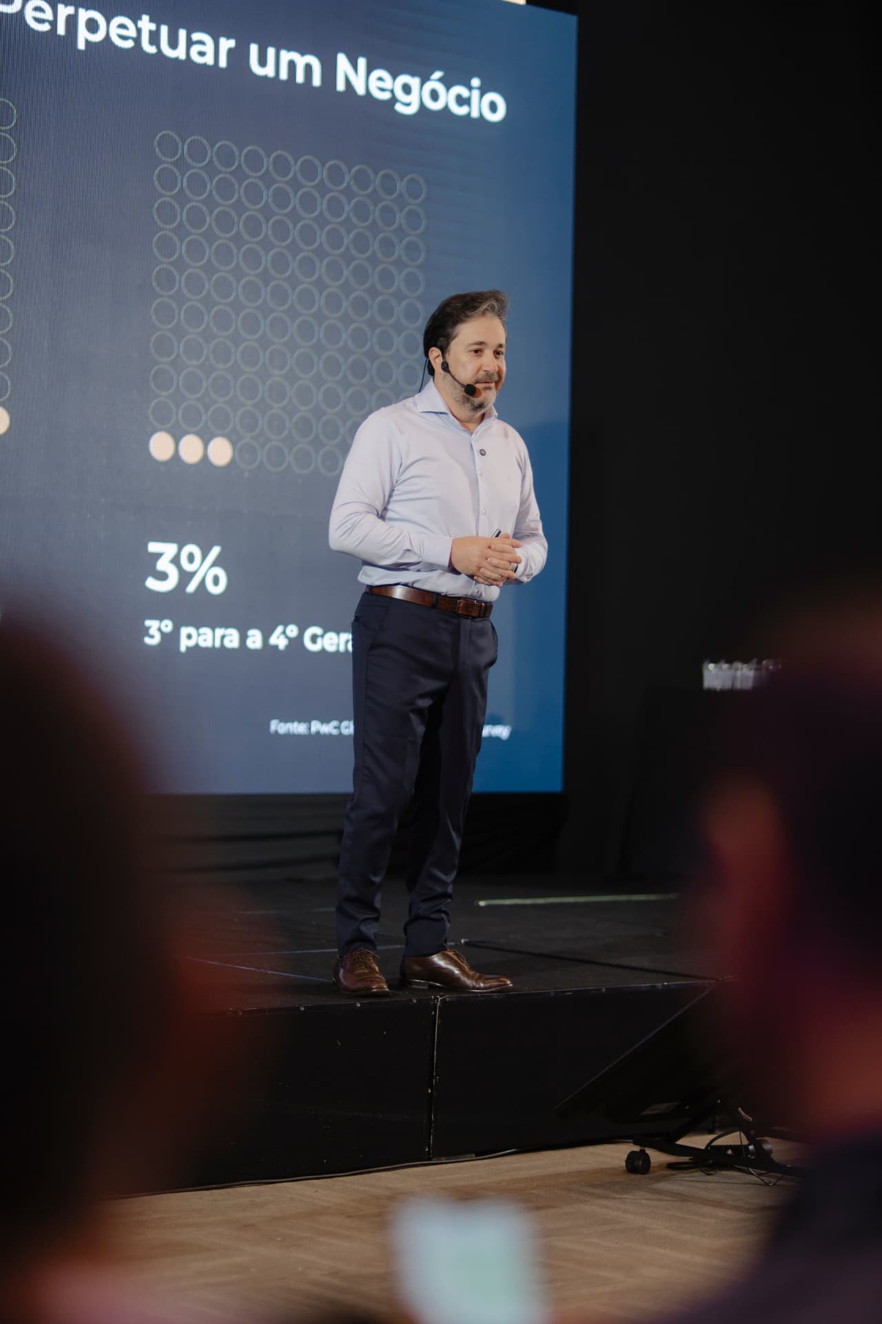 Palestrante no palco durante apresentação sobre perpetuação do negócio